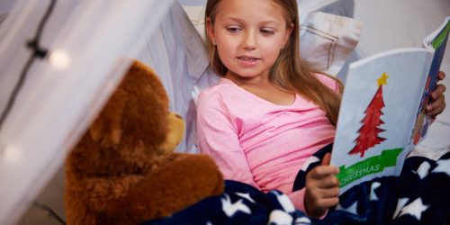 girl-reading-storybook-with-her-teddy-bear