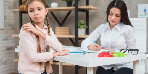 psychologist-writing-notes-clipboard-during-meeting-with-her-depressed-girl